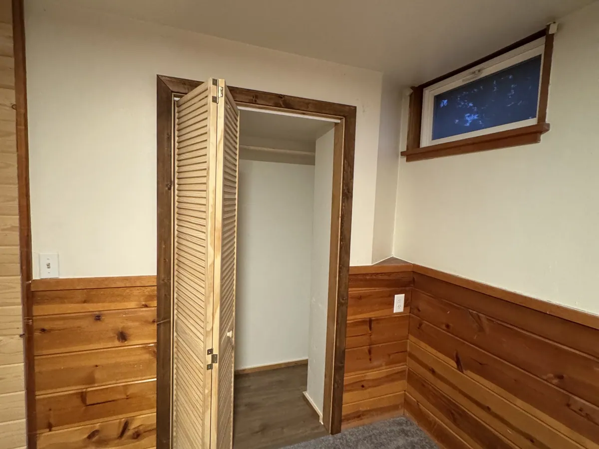 Newly framed closet with bifold door and cedar wainscot