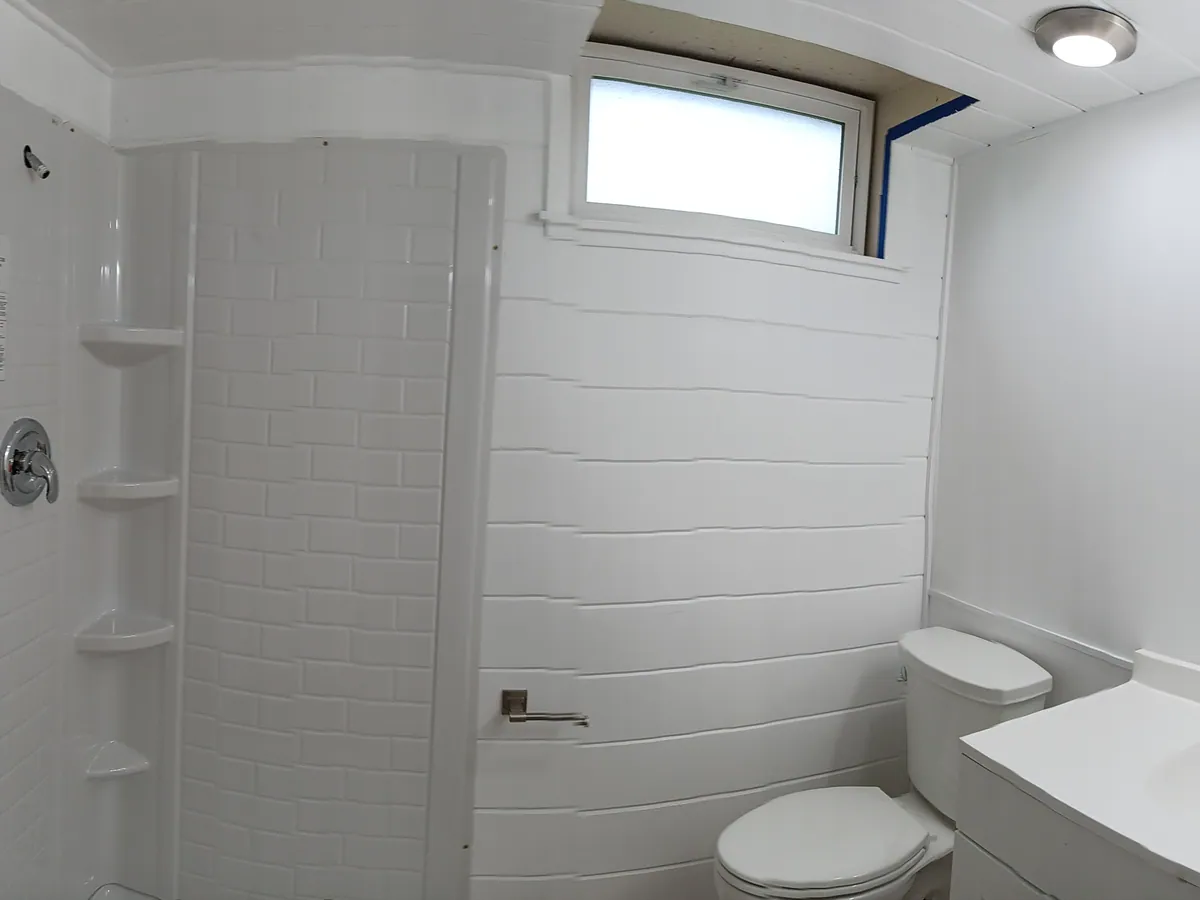 New shower with tiled surround and fixtures installed