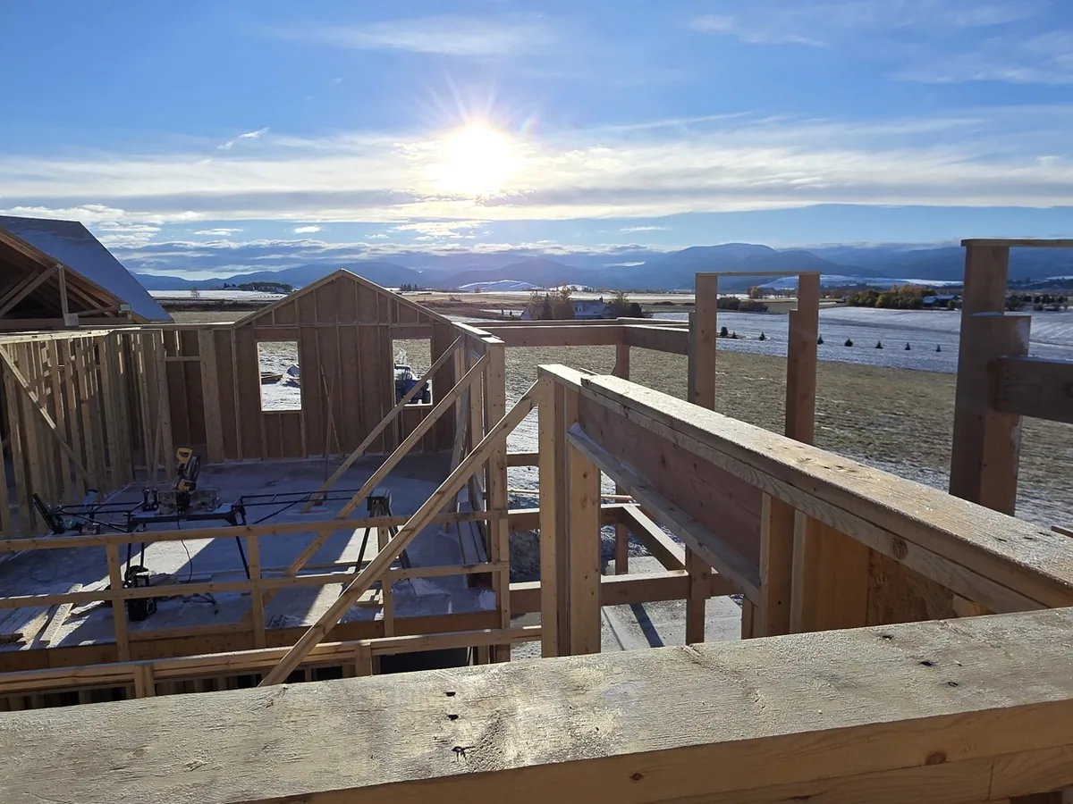 Framing on one of our job sites at sunrise, with the Montana valley behind