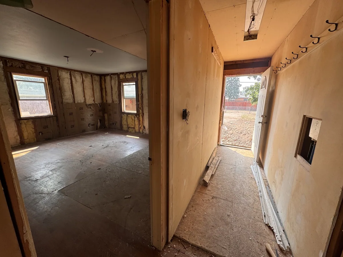 Interior of a house stripped back to bare studs and subfloor during demolition