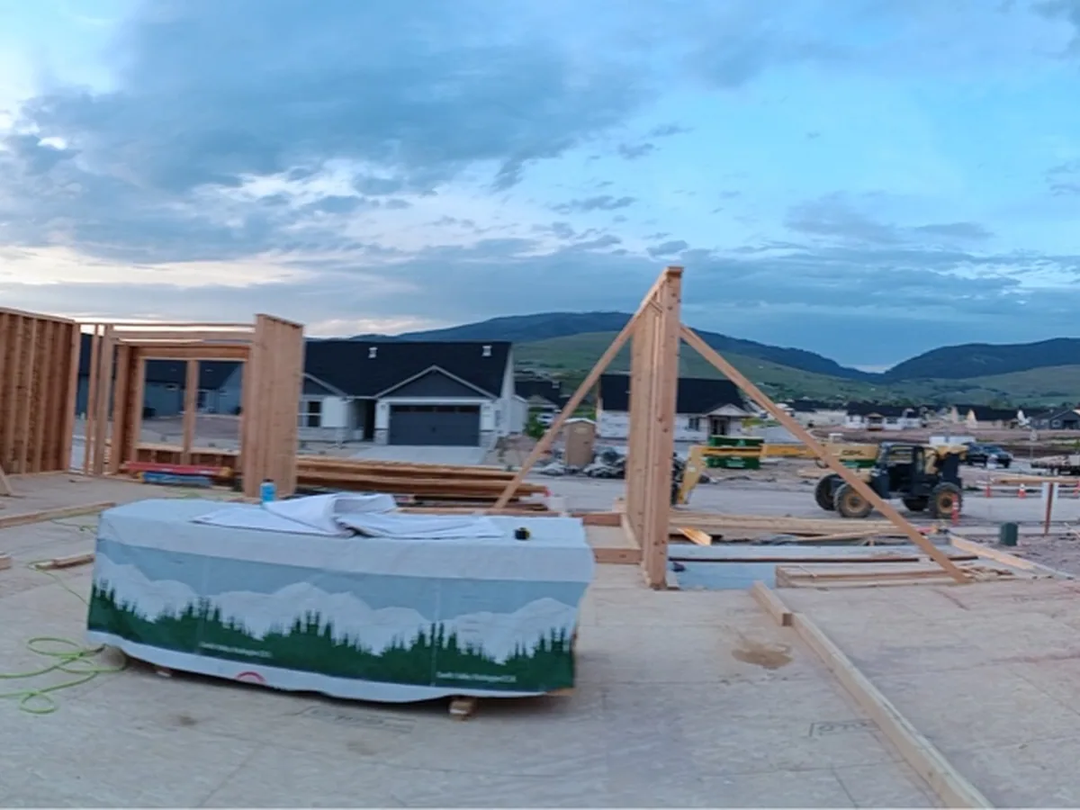Framing going up around a new hot tub on a concrete slab with mountains behind